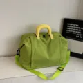 Green travel duffel bag with yellow handles, spacious capacity for short trips and gym use. - Green