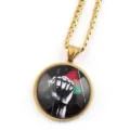 Collier chaîne doré avec pendentif cabochon en verre rond et motif de poing de solidarité. - Or G