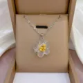 Detailansicht einer modischen mattierten Blumen-Halskette mit funkelnden Zirkonia-Kristallen. - X0953 Silber Matt Gelb Herz Blume