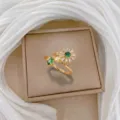 Eleganter goldener Blumenring mit grünen und weißen Zirkonia Steinen für Damen und Mädchen. - Offener Ring mit grünem Herzen (J0230)