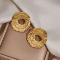 Detailed shot of textured gold-plated stainless steel hoop earrings, elegant niche design jewelry. - Round Texture Style (1139) / Gold