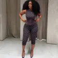 Gedetailleerd overzicht van de zwart-roze gestipte mouwloze top en capribroek set. - S / Top en Broek / Zwart