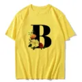 Vue rapprochée du t-shirt jaune avec une grande lettre B noire et un imprimé floral vintage. - S / Hauts / Lettre B