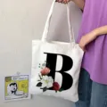 Borsa shopper in tela con elegante lettera B e stampa floreale, ideale per lo shopping. - Lettera B / 15x13