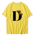 T-shirt femme jaune à manches courtes avec grande lettre noire D et imprimé floral vintage. - S / Hauts / Lettre D