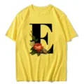 Yellow short sleeve t-shirt featuring a large black letter E and vintage floral print. - S / Tops / Letter E