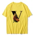 Detailed view of the yellow short sleeve t-shirt featuring a vintage floral letter V design. - S / Tops / Letter V