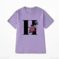Gedetailleerd zicht op paars t-shirt met korte mouwen, zwarte letter H en bloemenprint. - S / Paars (Letter H)