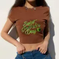 Brown crop top detail showing Saint Patrick's Day shamrock holiday print and slim fit cut. - S / Brown