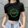 St. Patrick's Day crop top detail view, showcasing clover wreath graphic and black slim fit. - S / Black