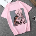 Detail view of pink short sleeve t-shirt featuring skeleton and cat graphic print design. - Pink (21059)
