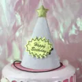 Sparkly silver birthday hat with gold star and party decorations for kids celebration. - Glitter Silver