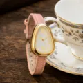 Rosa Lederarmband Uhr mit einzigartigem Dreiecks-Schlangenkopf-Goldgehäuse und weißem Zifferblatt. - Lotusrosa