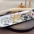 Nahaufnahme von luxuriösen Quarz Armreifuhren mit eckigen Zifferblättern und offenen Armbändern. - Römische Ziffern Gold