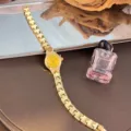 Detail shot of a delicate gold quartz watch featuring a small yellow dial and fine metal link bracelet. - Gold Dial / Gold