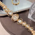 Detailed view of gold-tone women quartz watch with rhinestone crystal links and decorative band. - White