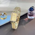 Nahaufnahme einer glamourösen, echten Strass-Quarzuhr mit doppelter Gliederarmband-Kette. - Ganz Gold