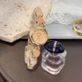 Detailaufnahme einer Vintage Damenuhr mit Quarzwerk, rosa Perlenarmband und goldenem Zifferblatt. - Rosa Goldenes Zifferblatt