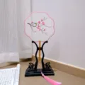 Handcrafted traditional Chinese embroidered round fan with pink tassel and elegant black display stand. - 4