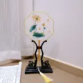 Traditional Chinese embroidered round fan with wooden stand and tassel, elegant decor. - 1