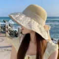 Women summer straw sun hat with lace brim and elegant ribbon bow for beach travel protection. - Lace Bow Straw Hat / Beige