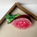 Cute fruit hair claw clip detail shot, showing vibrant pink and green acrylic texture for daily styling. - Fruit