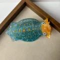 Cute creative sea slug hair claw clip detail, sparkling blue resin hair accessory with yellow details. - Squid