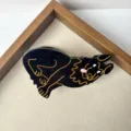 Detailed close-up of a cute black dog hair claw clip with gold outline design for women. - Black German Shepherd Style