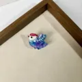 Close-up detail of a cute blue and purple acrylic bird hair claw clip, charming accessory. - Size 9