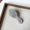Gros plan sur la mini brosse à cheveux en acétate, peigne de massage de voyage compact détail. - 1