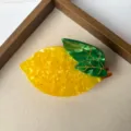 Cute lemon hair claw clip detail view, bright yellow fruit design with green leaf accessory. - Lemon