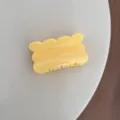 Primer plano detallado de una pinza para el pelo amarilla con borde ondulado, estilo chic. - Estilo de Galleta / Amarillo