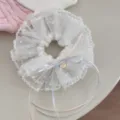 Gros plan d'un chouchou en dentelle coréenne douce avec des nœuds rubans pastel et détails. - Élastique à cheveux ruban blanc