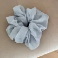 Close-up detail view of the light blue gingham chiffon scrunchie showing soft pleated texture. - Blue Checkered Fabric