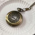 Antikes bronzenes Taschenuhr Detail, hohle florale geschnitzte Quarzuhr mit Kette. - Bronze