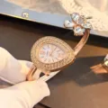 Elegant rose gold quartz watch with teardrop dial and crystal clover accent for women. - Rose Gold
