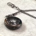 Nahaufnahme Detail der vintage schwarzen hohl geschnitzten Quarzuhr Taschenuhr mit Kette. - Gunmetal