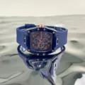 Transparente Tonneau Quarzuhr mit blauem Silikonarmband und roségoldenen Zifferblattdetails. - Blau