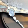 Nahaufnahme der eleganten silbernen Quarzuhr mit unregelmäßigem Metallarmband und Zifferblatt. - Silber Weiß
