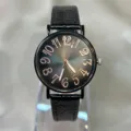 Primer plano detallado de reloj de mujer con esfera degradada efecto sol y correa de piel negra. - Negro
