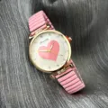 Nahaufnahme Detail der Damen Quarzuhr mit rosa elastischem Armband und Strass Herz Zifferblatt. - Rosa