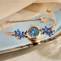 Close-up detail view of the rose gold quartz bracelet watch with blue flower crystals. - Blue