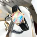 Detailansicht des Regenbogen-Zifferblatts mit schwarzem Stretcharmband und Roségoldgehäuse. - Schwarz