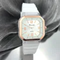 Detalle cercano del reloj de cuarzo cuadrado con correa de silicona blanca y bisel. - Blanco