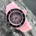 Detailaufnahme einer stilvollen Quarzuhr mit rosa Silikonarmband und einem Farbverlauf. - Rosa