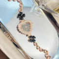 Women's rose gold quartz watch with heart rhinestone dial and black clover bracelet design. - Black