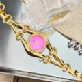 Nahaufnahme einer luxuriösen goldenen Damen Quarzuhr mit pinkem Zifferblatt und Kettengliedern. - Fuchsia