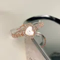 Detailaufnahme der herzförmigen Strass-Quarzuhr im eleganten Roségold-Design für Damen. - Roségold Weiß