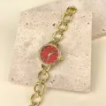 Nahaufnahme einer goldenen Strass-Quartzuhr für Damen mit einem auffallenden roten Zifferblatt. - Rotes Zifferblatt / Gold