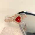 Elegante roségoldene Herz Quarz Uhr mit Strass Lünette und Blumen Armband für Damen. - Rot